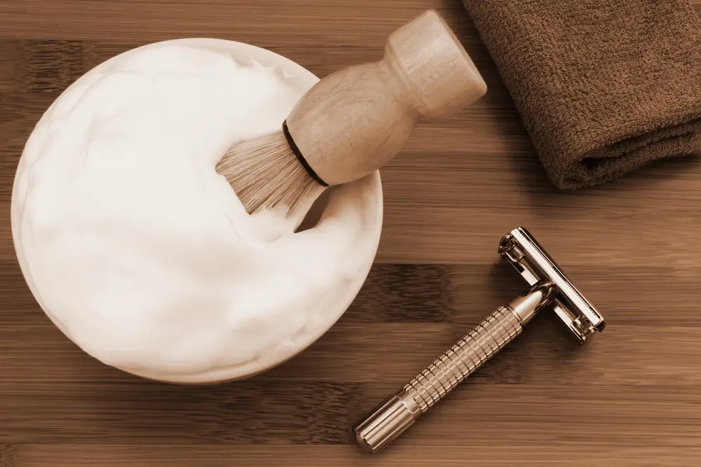 shaving brush in shaving foam with a safety razor