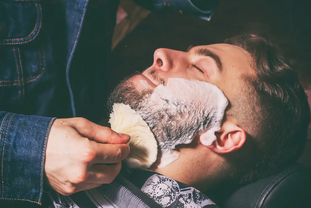 man getting shaving soap applied