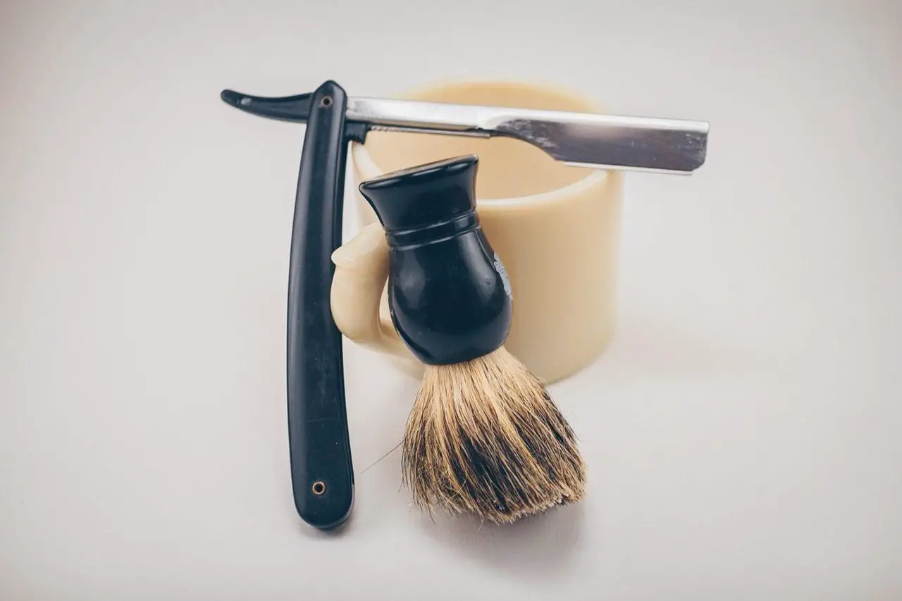 a shaving razor, brush, and cup
